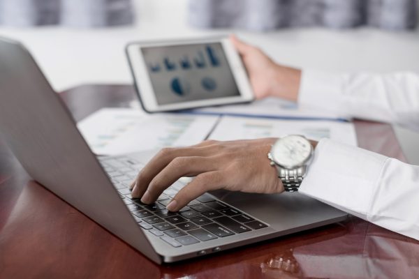 The businessman hand sits at their desks and calculates financia The businessman hand sits at their desks and calculates financial graphs showing the results of their investments planning the process of successful business growth.